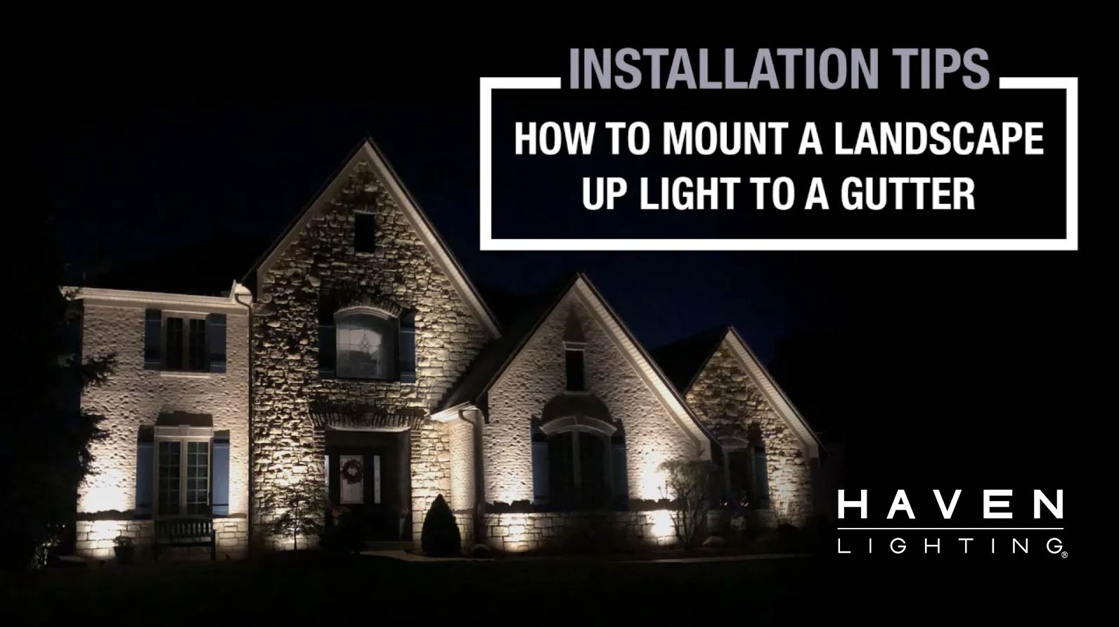House illuminated by landscape lights with 'Haven Lighting' text overlay