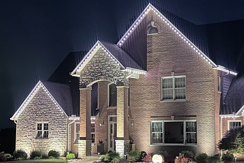 Two-story house with Haven Classic
decorative lights on the roof at night