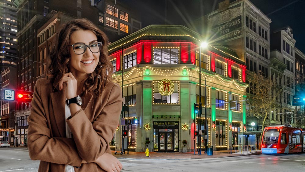 Woman in front of a building downtown decorated for Christmas