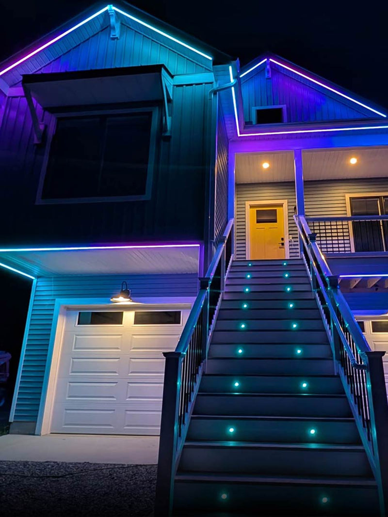 Home with permanent roofline lighting and matching hardscape lighting on the same system